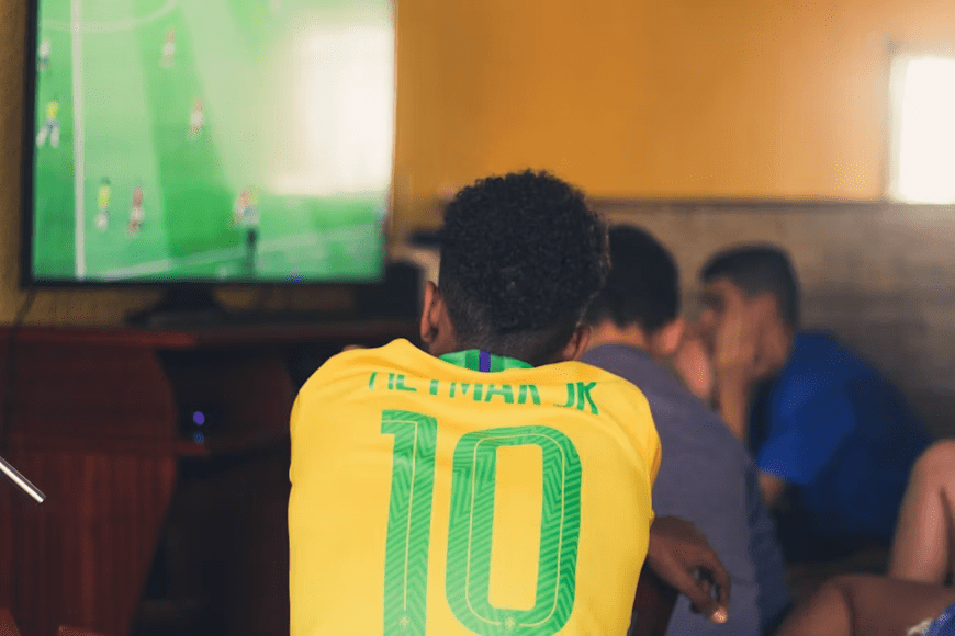 Sports fan watching a favorite team on television with team-focused match coverage.